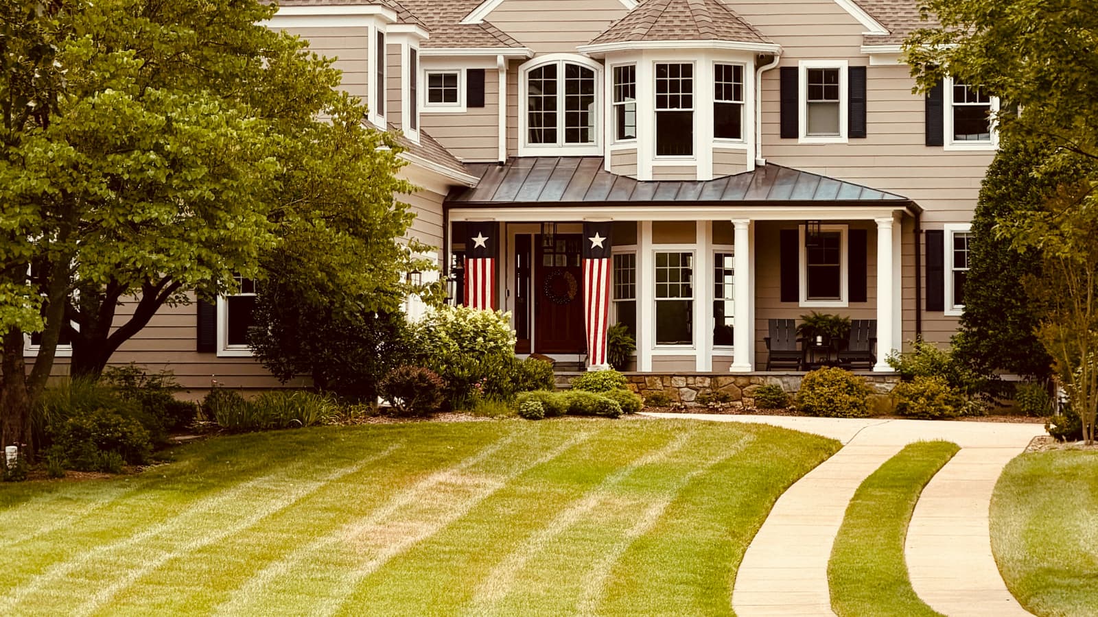Two-story suburban home with a freshly striped front lawn